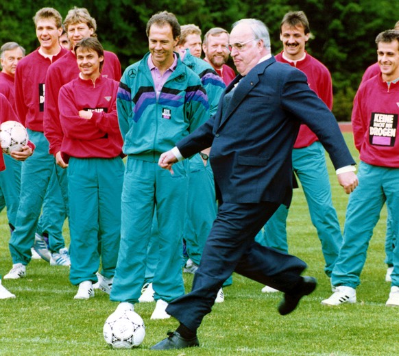Italia world cup soccer preperations. German Chancellor Helmut Kohl (center right) kicking a ball during his visit to the trainings-camp of German national soccer team in Kamen near Dortmund while Tea ...