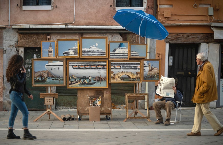 A street stall with oil paintings creating an image of a yacht in the Venice canal with a sign reading &quot;Venice in oil&quot;, set up by a person purporting to be British artist Banksy, in Venice,  ...