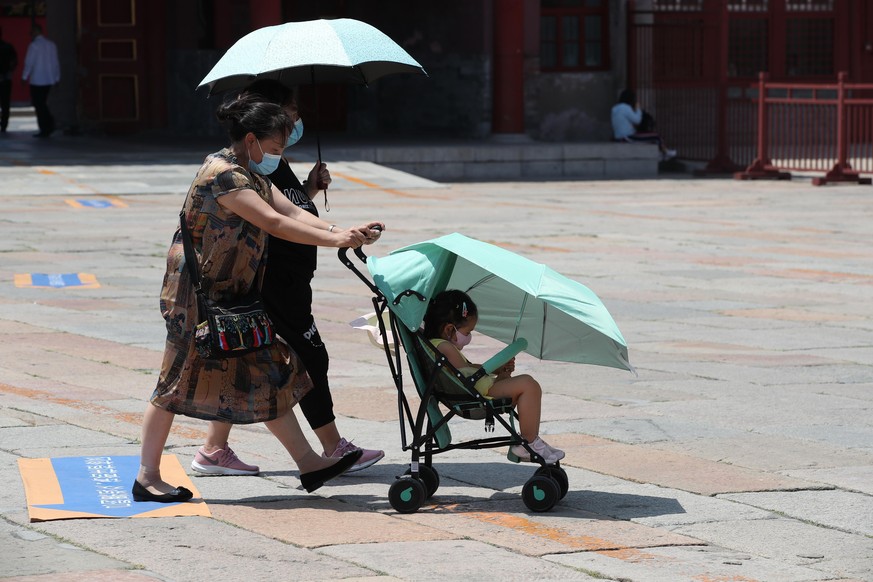 12.06.2020, China, Peking: People covered with clothes, unbrella and masks walk under the sun in Beijing, China, 12 June 2020. Foto: Wang Xin/HPIC/dpa |