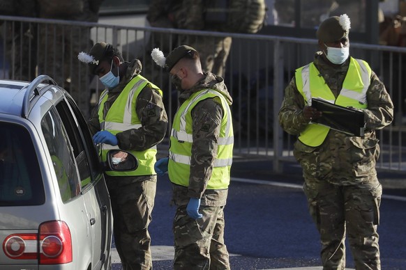 25.12.2020, Großbritannien, Dover: Soldaten führen Corona-Test bei einem Autofahrer vor dem Hafen von Dover durch. Obwohl Frankreich die Grenze zu Großbritannien wieder geöffnet hat, werden zahlreiche ...