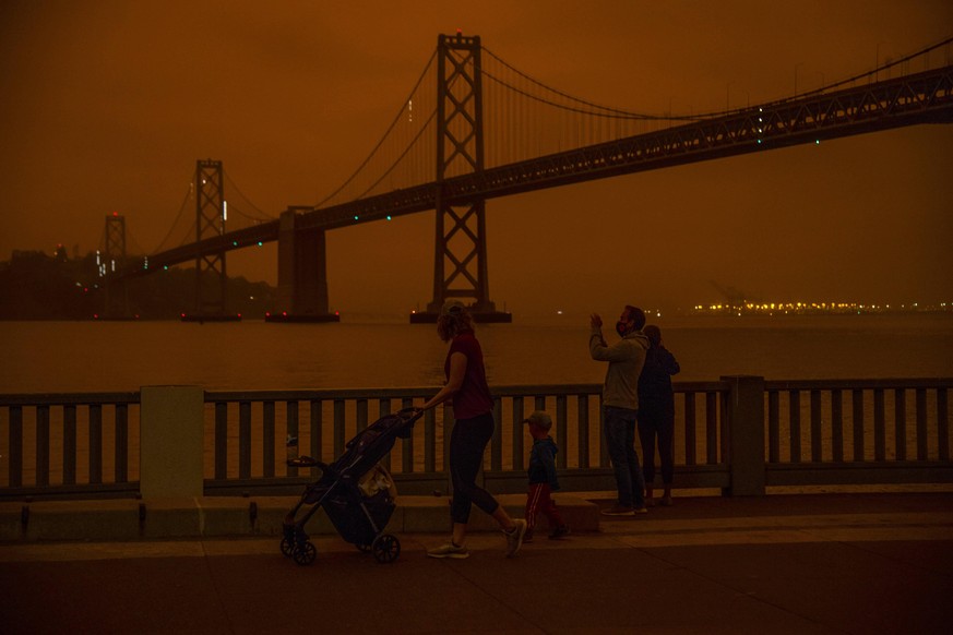 An errie mixture of fog and smoke casts an orange glow over San Francisco and the Bay Bridge at 10:10 in the morning along the Embarcadero on Wednesday, September 9, 2020. The Bay Area is experiencing ...