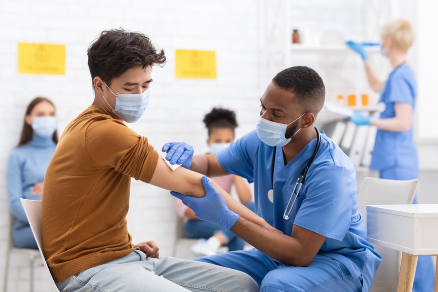 Covid-19 Vaccination. Asian Male Patient Getting Vaccinated Against Coronavirus Receiving Covid Vaccine Intramuscular Injection During Doctor&#039;s Appointment In Hospital. Corona Virus Immunization