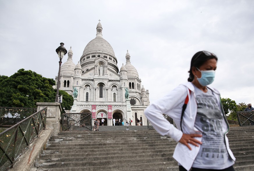 10.08.2020, Frankreich, Paris: Eine Frau steigt die Stufen vor der Basilika Sacre-Coeur auf dem Montmartre hinab. Im Kampf gegen Corona gilt nun auch in Paris eine Maskenpflicht an zahlreichen