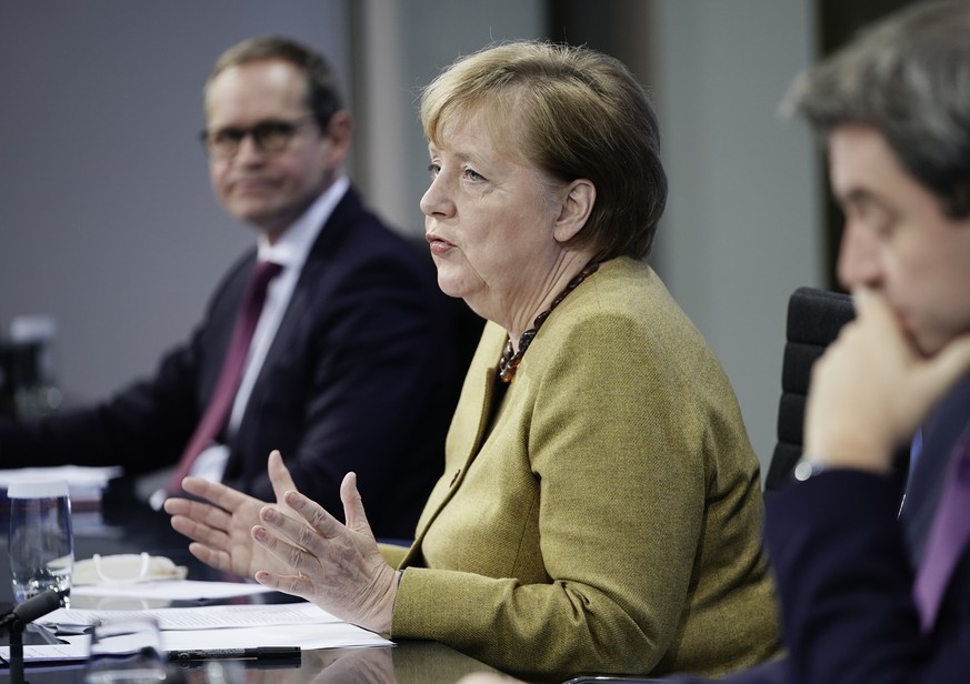 Germany&#039;s Chancellor Angela Merkel joins Markus Soeder (CSU), right, Prime Minister of Bavaria and CSU Chairman, and Michael Mueller (SPD), Governing Mayor of Berlin in a press conference followi ...