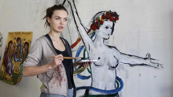 Oksana Shachko, activist of women&#039;s rights group Femen, speaks while painting a wall of her room in Kiev, Ukraine February 21, 2012. Picture taken February 21, 2012. REUTERS/Gleb Garanich