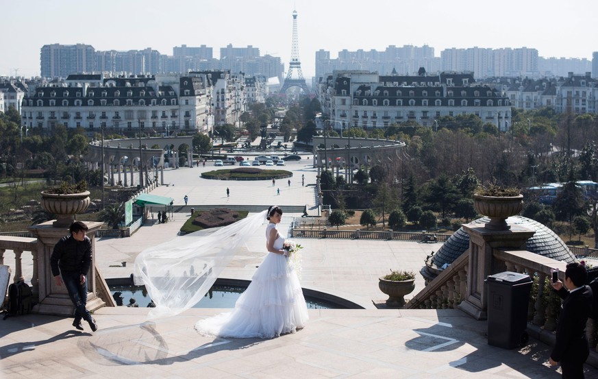 This photo taken on January 26, 2016 shows a young Chinese couple posing for wedding photos in front of Parisian-style architecture at Tianducheng, a small Chinese community replicating Paris, includi ...