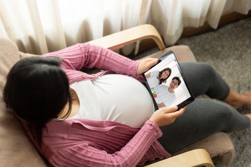 Family and pregnant woman video call while stay safe at home during covid-19 coronavirus outbreak. Concept of people connection call technology with online video camera.
