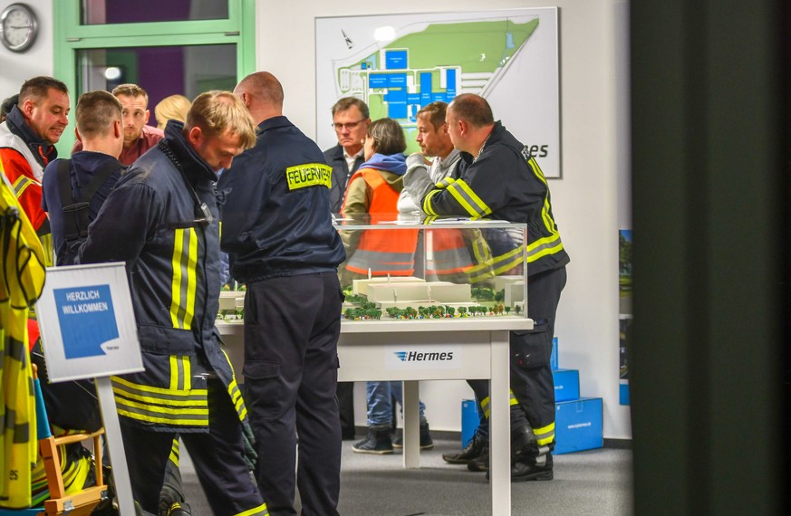 15.10.2019, Sachsen-Anhalt, Haldensleben: Mitarbeiter der Feuerwehr stehen im Hermes Logistikzentrum. Foto: Tom Wunderlich/dpa-Zentralbild/dpa +++ dpa-Bildfunk +++