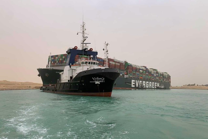 CORRECTS NAME OF SHIP TO EVER GIVEN, NOT EVER GREEN - In this photo released by the Suez Canal Authority, a boat navigates in front of a cargo ship, Ever Given, Wednesday, March 24, 2021, after it bec ...