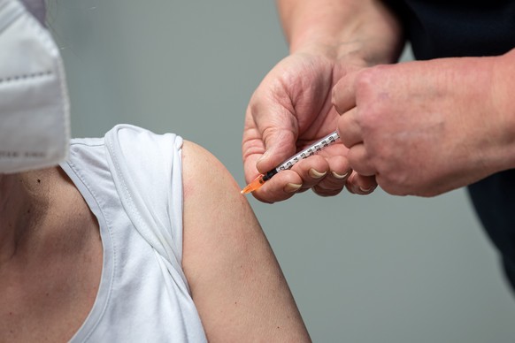 ILLUSTRATION - 29.12.2020, Niedersachsen, Nordhorn: Eine Frau wird im Impfzentrum gegen das Coronavirus geimpft. Zwei Tage nach dem Start der Corona-Impfungen in Niedersachsen sind die ersten Menschen ...