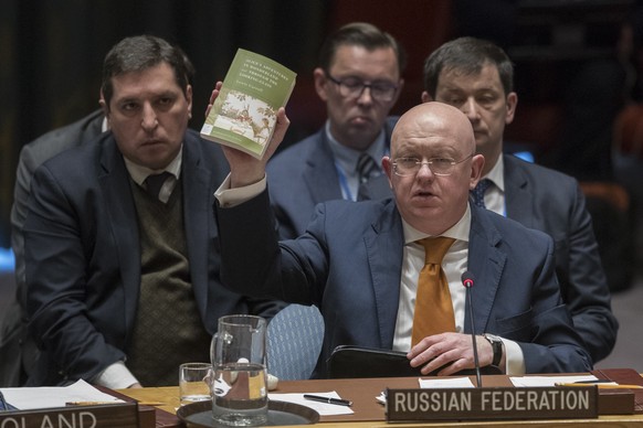 Russian Ambassador to the United Nations Vassily Nebenzia holds up a copy of &quot;Alice&#039;s Adventures in Wonderland&quot; as he speaks during a Security Council meeting on the situation between B ...