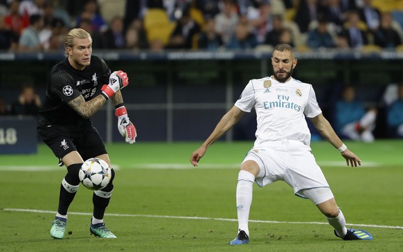 Real Madrid&#039;s Karim Benzema, right, scores against Liverpool goalkeeper Loris Karius during the Champions League Final soccer match between Real Madrid and Liverpool at the Olimpiyskiy Stadium in ...