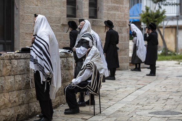 Orthodoxe Juden beten vor einer Synagoge im jüdisch-orthodoxen Viertel Mea She'arim, nachdem sie am Ritual der Brotverbrennung teilgenommen haben.