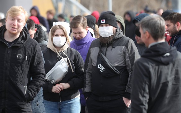 MOSCOW, RUSSIA - MARCH 15, 2020: Fans in face masks are seen outside VTB Arena ahead of a concert by the German-Swedish industrial metal duo Lindemann. The German-Swedish duo, who are on their 2020 to ...