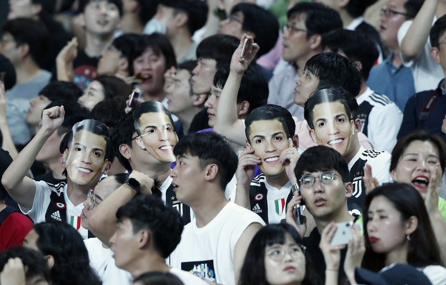 South Korean soccer fans wear masks of Cristiano Ronaldo of Juventus prior to a friendly match between Juventus and Team K League at the Seoul World Cup Stadium in Seoul, South Korea, Friday, July 26, ...