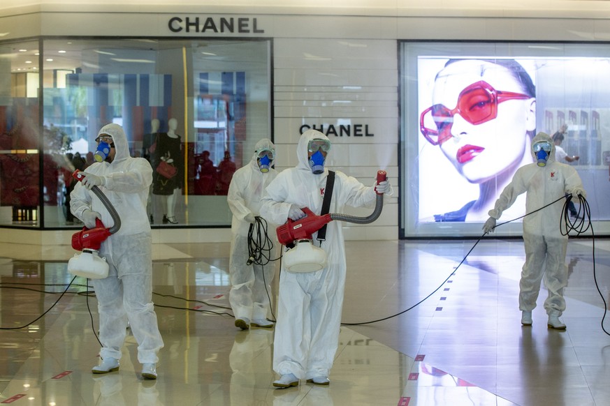 Cleaners in hazmat suits demonstrate disinfection as workers remodel a display window at Siam Paragon, an upmarket shopping mall in Bangkok, Thailand, Thursday, May 14, 2020. Shopping malls in Thailan ...