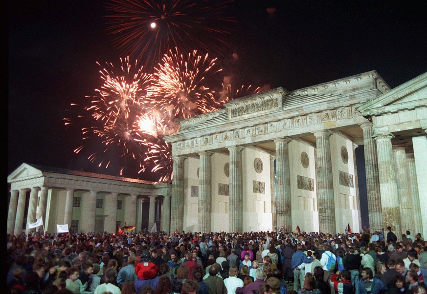 ARCHIV - 03.10.1990, Berlin: Mit einem Feuerwerk am Brandenburger Tor in Berlin feierten rund eine Million Menschen in der Nacht vom 02. auf den 03. Oktober die deutsche Wiedervereinigung. 30 Jahre na ...