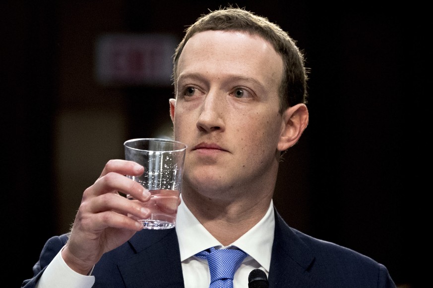 Facebook CEO Mark Zuckerberg takes a drink of water while testifying before a joint hearing of the Commerce and Judiciary Committees on Capitol Hill in Washington, Tuesday, April 10, 2018, about the u ...