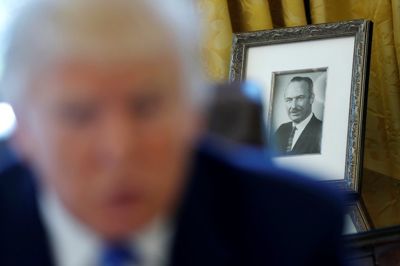 FILE PHOTO: A photo of U.S. President Donald Trump&#039;s late father Fred Trump sits behind him as he gives an interview with Reuters in the Oval Office at the White House in Washington, U.S., Februa ...