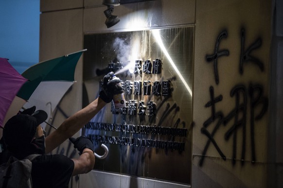 July 21, 2019 - Hong Kong, Hong Kong - A Protester is seen spray painting a plague outside the Liaison Office in Hong Kong On July 21, 2019, Protesters surround the Chinese Liaison Office in Hong Kong ...