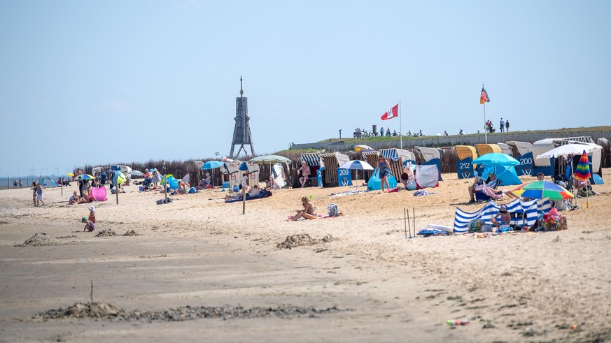 26.06.2020, Niedersachsen, Cuxhaven: Urlauber sitzen bei Sonnenschein am Strand. Foto: Sina Schuldt/dpa +++ dpa-Bildfunk +++