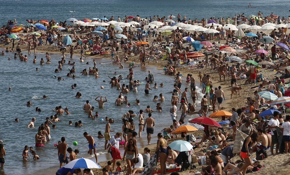 People sunbathe on a beach in Barcelona, Spain, Wednesday, Aug. 1, 2018. Much of Spain is on alert as the country&#039;s weather agency warns that temperatures could surpass 40 degrees Celsius (104 Fa ...