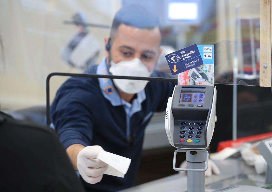 A cashier of the food discounter ALDI serves a customer, as the spread of the coronavirus disease (COVID-19) continues in Duesseldorf, Germany, April 29, 2020. REUTERS/Wolfgang Rattay