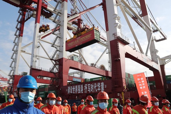 QINGDAO, CHINA - JANUARY 19: A container is loaded onto a cargo ship during the ceremony for the Opening of Belt and Road RCEP Line, including EMC Southeast Asia Line, WHL/IAL Vietnam Line and WHL/IAL ...