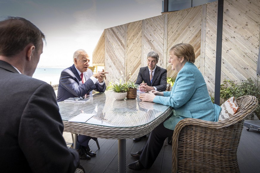 HANDOUT - 12.06.2021, Großbritannien, St.Ives: Bundeskanzlerin Angela Merkel (CDU) und US-Präsident Joe Biden (2.v.l.) sitzen zu Beginn ihres Gesprächs am Rande des G7-Gipfels mit ihren außenpolitisch ...