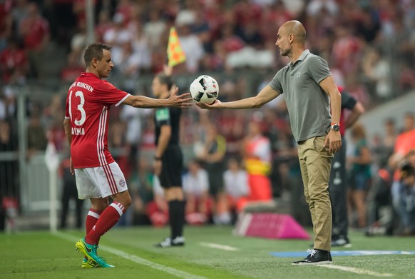 Manchester&#039;s head coach Pep Guardiola (front R) passes the ball to Munich&#039;s Rafinha during an international soccer friendly match between FC Bayern Munich and Manchester City at the Allianz  ...