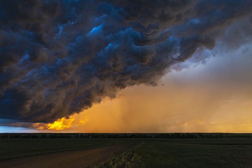 Dark, turbulent, stormy sky with rain curtain at sunset in South Dakota