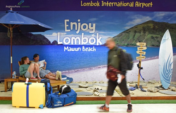 Foreign tourists sit at a photo booth as their flight to Bali was canceledled due to Mount Agung&#039;s eruption, at Lombok International airport in Lombok Tengah, Indonesia, June 29, 2018. Antara Fot ...