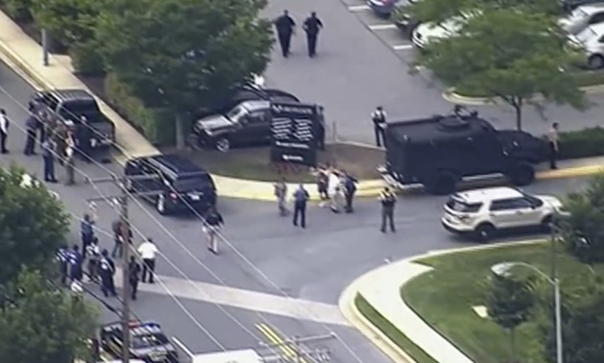 In this frame from video, people leave the Capital Gazette newspaper after multiple people have been shot on Thursday, June 28, 2018, in Annapolis, Md. (WJLA via AP)