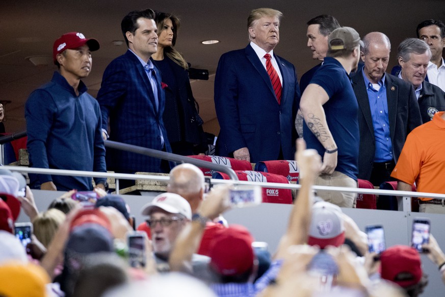 President Donald Trump, center, and first lady Melania Trump, third from left, accompanied by Rep. Matt Gaetz, R-Fla., second from left, Sen. David Perdue, R-Ga., fifth from left, and Rep. Mark Meadow ...