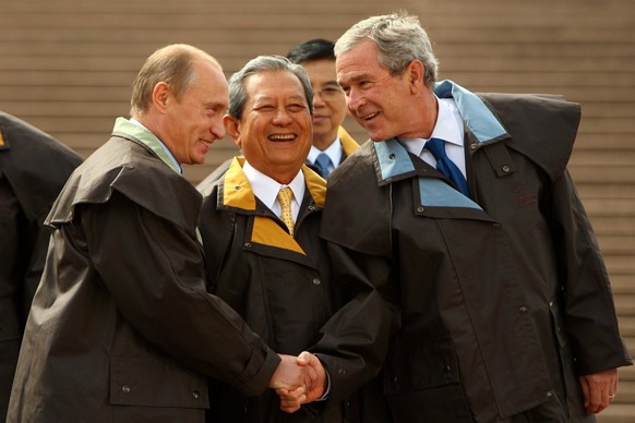 SYDNEY, AUSTRALIA - SEPTEMBER 08: (L-R) Russian President Vladamir Putin Thai Prime Minister Surayud Chulanont and US President George W Bush attend the Leaders official photograph wearing Driza-Bone  ...