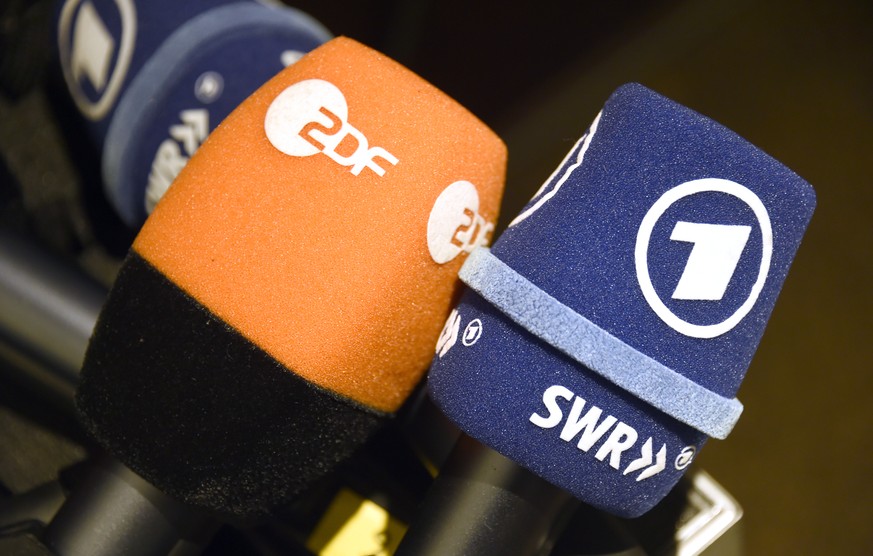 ARCHIV - 03.04.2014, Hamburg: Mikrofone mit den Logos der Fernsehsender ZDF und des ARD-Senders SWR liegen w