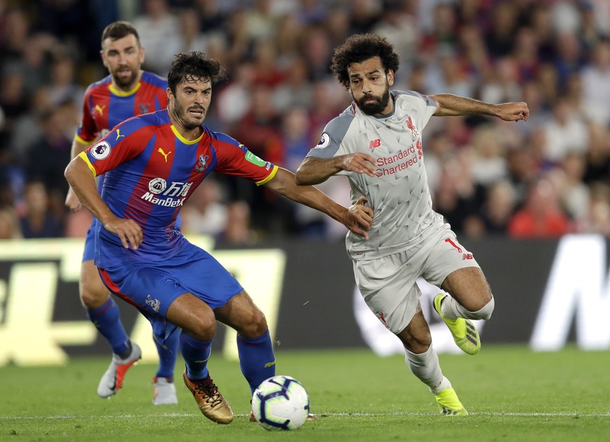 Crystal Palace&#039;s James Tomkins, left, duels for the ball with Liverpool&#039;s Mohamed Salah during the English Premier League soccer match between Crystal Palace and Liverpool at Selhurst Park s ...