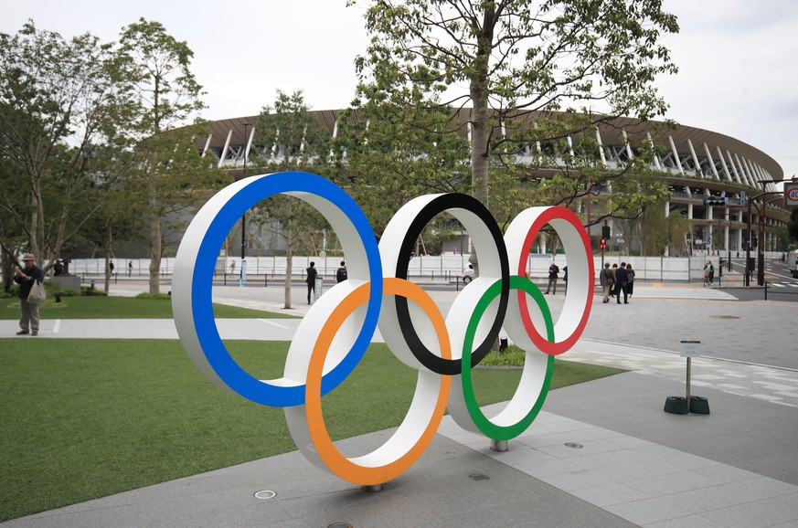 ARCHIV - 07.05.2021, Japan, Tokio: Die Olympischen Ringe sind vor dem Olympischen Stadion aufgebaut. Angesichts steigender Infektionszahlen hat Japan den Corona-Notstand f