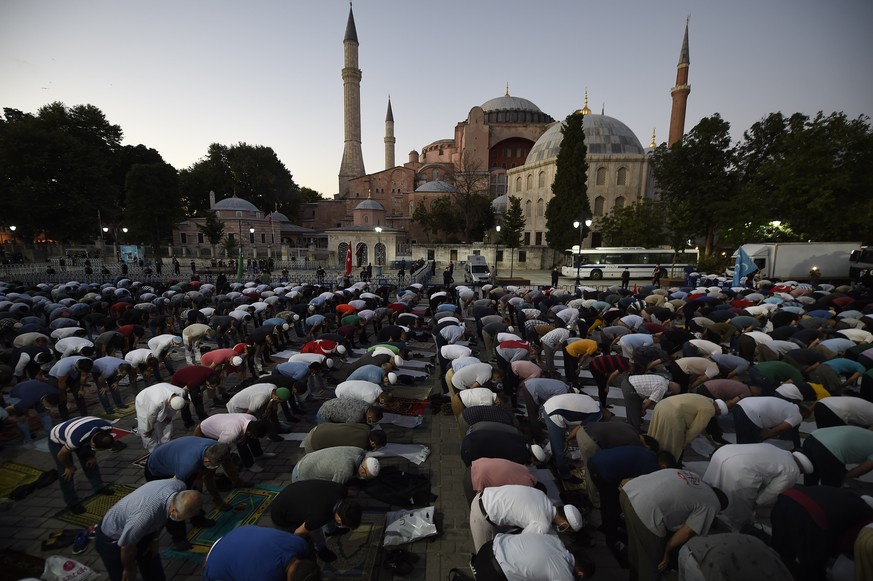 Muslims offer their evening prayers outside the Byzantine-era Hagia Sophia, one of Istanbul&#039;s main tourist attractions in the historic Sultanahmet district of Istanbul, following Turkey&#039;s Co ...