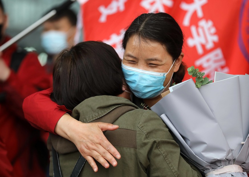 (200407) -- WUHAN, April 7, 2020 () -- A medical worker and a local resident hug each other at Wuhan Railway Station in Wuhan, central China&#039;s Hubei Province, April 7, 2020. The last batch of 186 ...