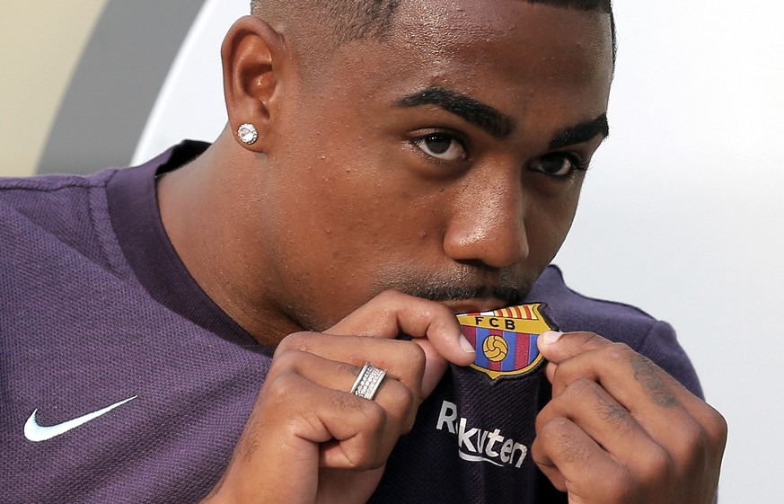 Brazilian soccer player Malcom Filipe Silva de Oliveira kisses the emblem on his shirt upon his arrival at the club&#039;s office at the Camp Nou stadium in Barcelona, Tuesday, July 24, 2018. Malcom h ...