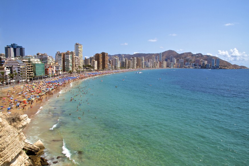 Wide angle of the Iconic hotel skyscraper skyline of Benidorm and Levante Beach, with unrecognisable people enjoying the sunshine and the Mediterranean Sea in Benidorm on the Costa Blanca, province of ...
