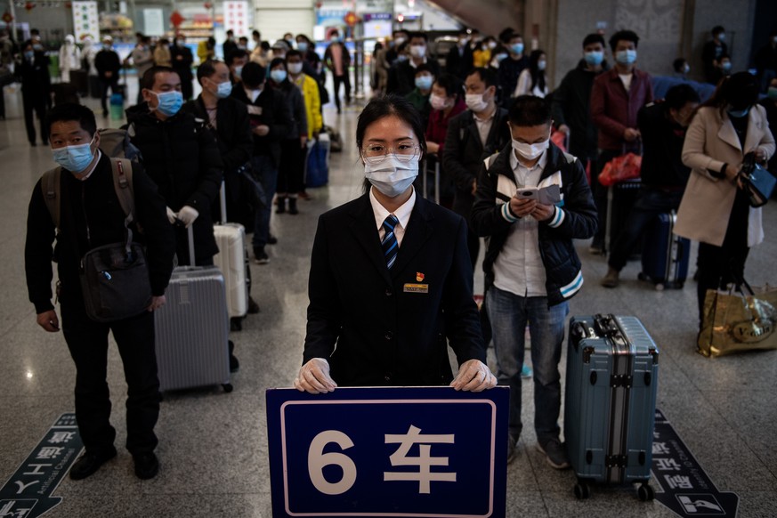 08.04.2020, Wuhan: Passengers wear face masks standing in line to take temperature check. 
At 00:50 on 8th, April, 2020, Trains K81 departs from Wuchang railway station in Wuhan, middle China&#039;s H ...