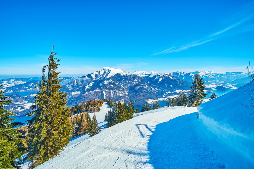 Enjoy the ski ride from the top of Zwolferhorn mountain with a view on incredible Alpine scenery on sunny winter day, St Gilgen, Salzkammergut, Austria