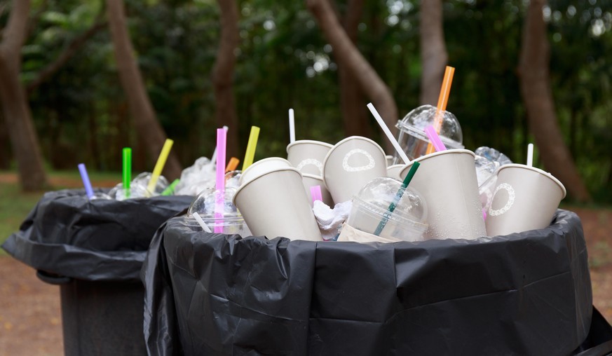 full refuse plastic and paper glass in plastic bin