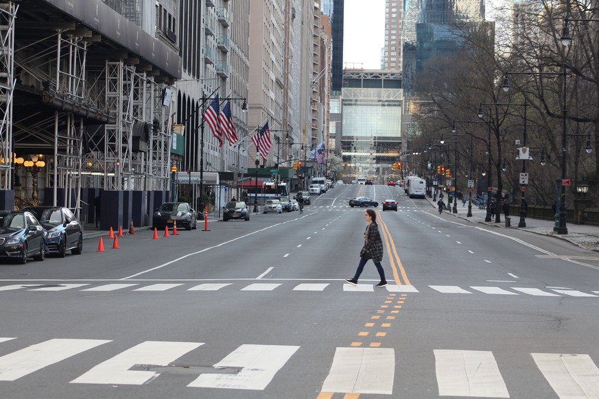 April 1, 2020, New York, New York, USA: An unprecedented situation in Big Apple. This young woman is crossing the notorious 5th Avenue emptied of cars as New York became the epicenter of the Coronavir ...