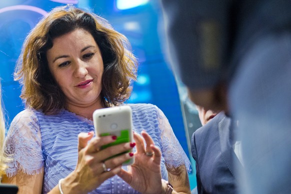 COLOGNE, GERMANY - AUGUST 21: German State Minister for Digitization Dorothee Baer tries an app on a smartphone at 2018 Gamescom video games trade fair press day on August 21, 2018 in Cologne, Germany ...