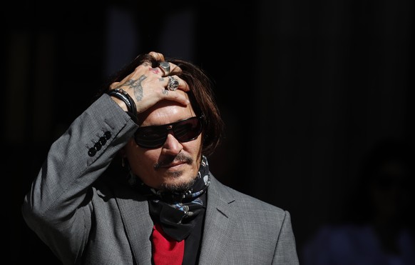 ARCHIV - 21.07.2020, Gro�britannien, London: Johnny Depp, Schauspieler aus den USA, f�hrt sich mit der Hand durch die Haare, als er am Obersten Gerichtshof eintrifft an einem Tag im Prozess um die Ver ...