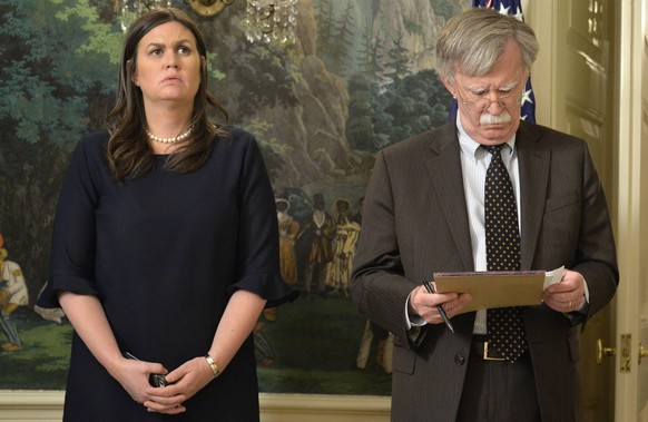 White House Press Secretary Sarah Huckabee Sanders L and National Security Advisor John Bolton listen to remarks by President Donald Trump as he speaks to the nation, announcing military action agains ...