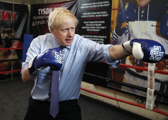 FILE - In this Tuesday, Nov. 19, 2019 file photo Britain&#039;s Prime Minister Boris Johnson poses for a photo wearing boxing gloves during a stop in his General Election Campaign trail at Jimmy Egan& ...
